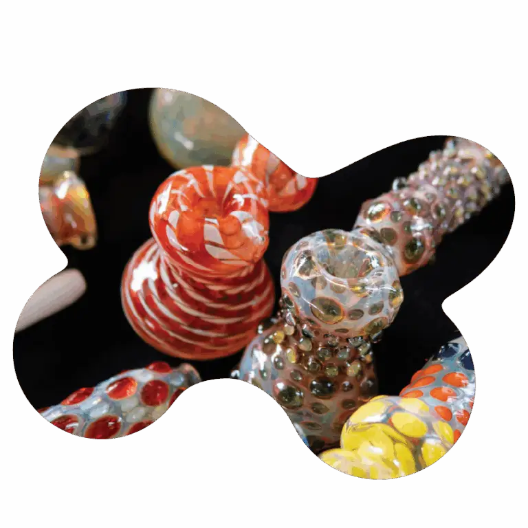 Colorful glass hand pipes and bubblers displayed on a black surface, showcasing cannabis accessories available at Housing Works Cannabis Co. dispensary.