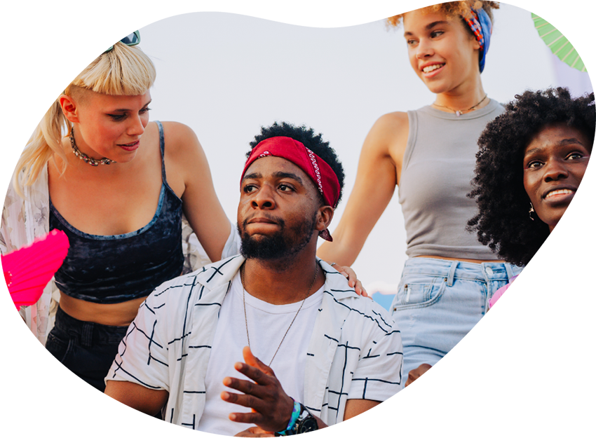 Group of young adults gathered outdoors, smiling and supporting each other, representing the community and harm reduction focus of Housing Works Cannabis Co.