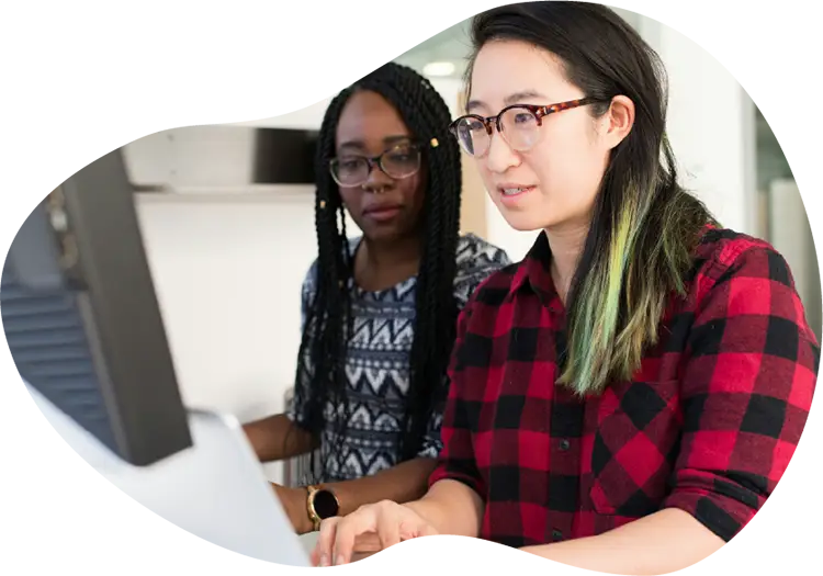 Two Housing Works team members collaborating at a computer in an office setting.